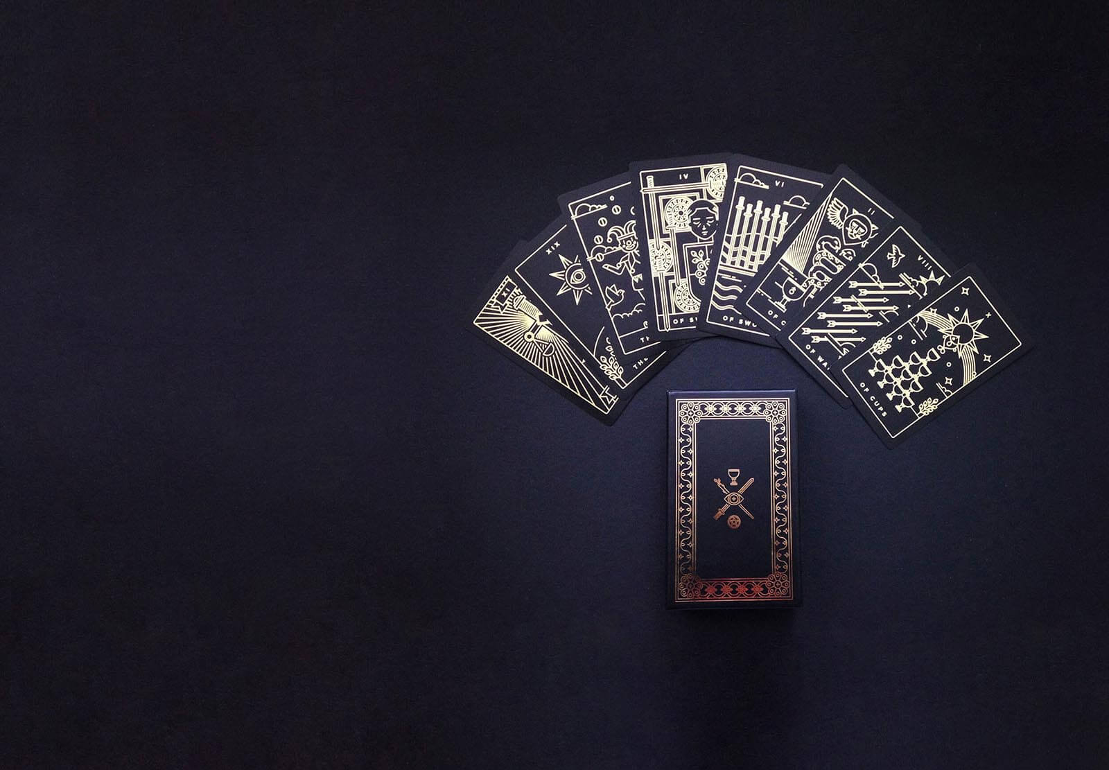 A minimalist iconographic tarot card deck printed with gold foil on sleek, matte, recycled plastic.