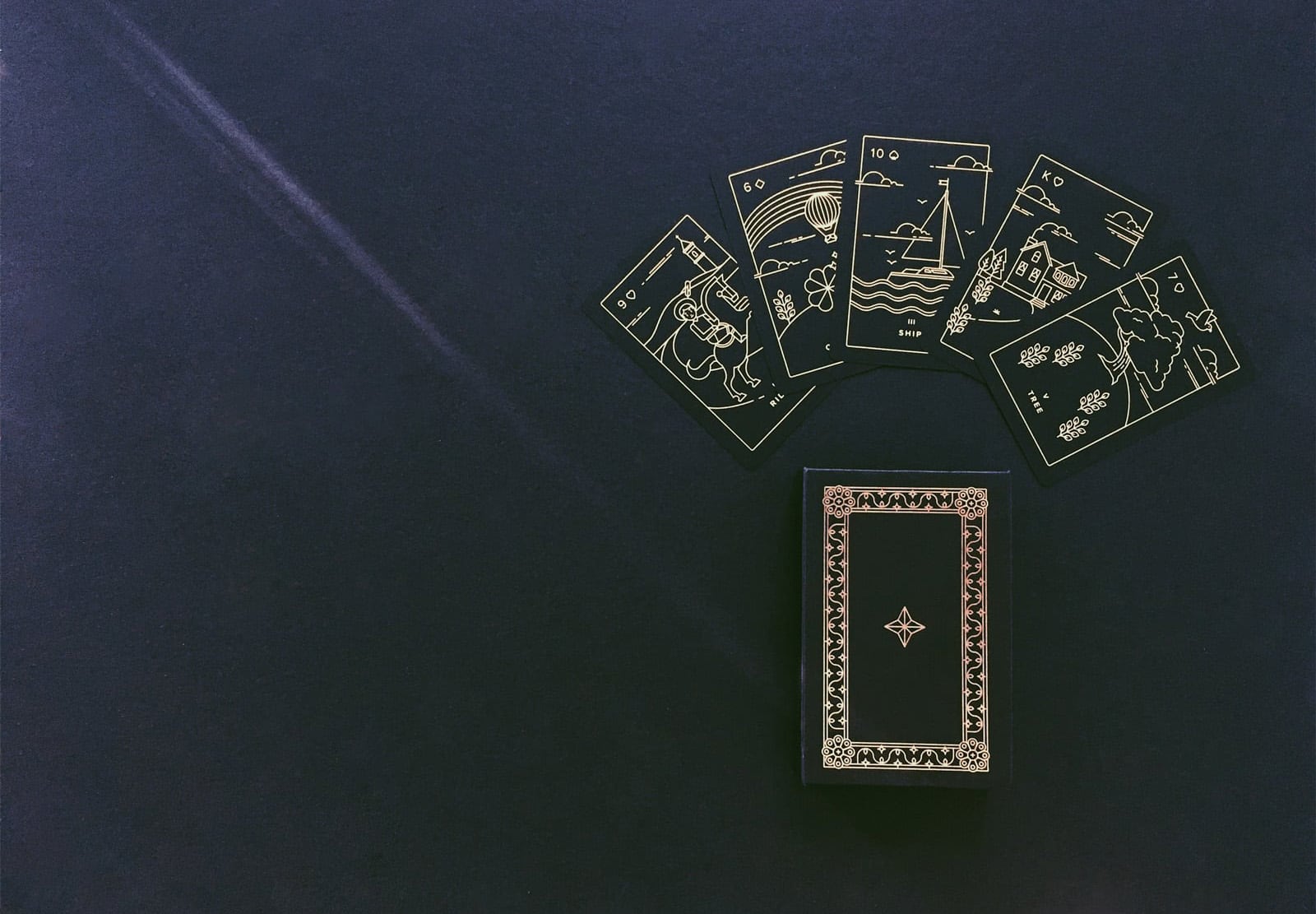 A minimalist and modern lenormand card deck printed with gold foil on sleek, matte, recycled plastic.