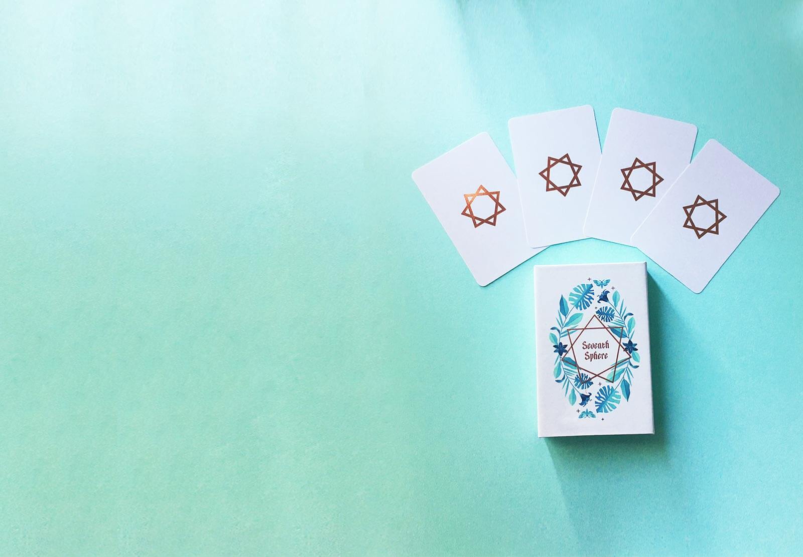 A modern Lenormand deck featuring rose gold detailing, rose gold edges, and bright colorful full-bleed illustrations.