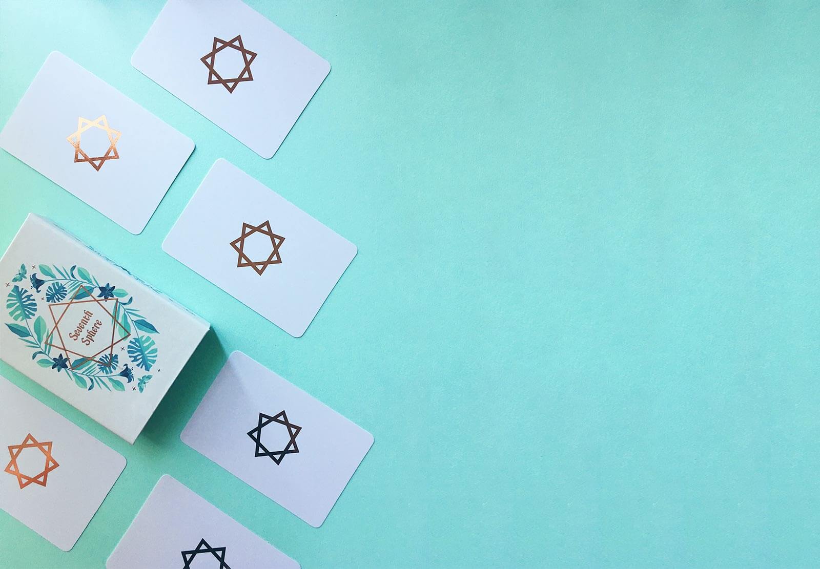 A modern Lenormand deck featuring rose gold detailing, rose gold edges, and bright colorful full-bleed illustrations.